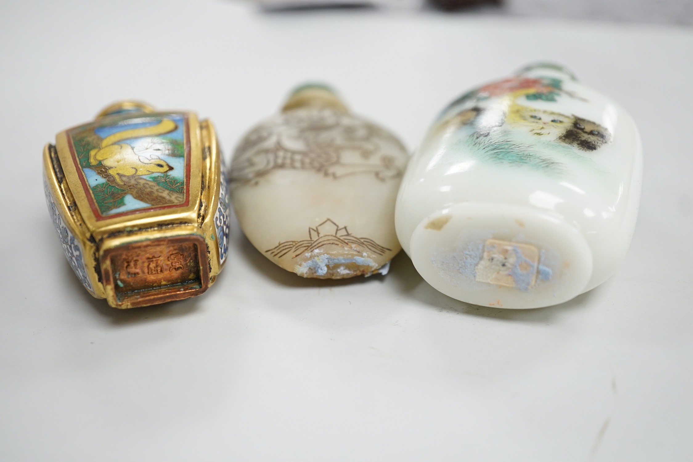 A Chinese cloisonné enamel snuff bottle, enamelled glass and stone snuff bottles. Tallest 8cm (3)